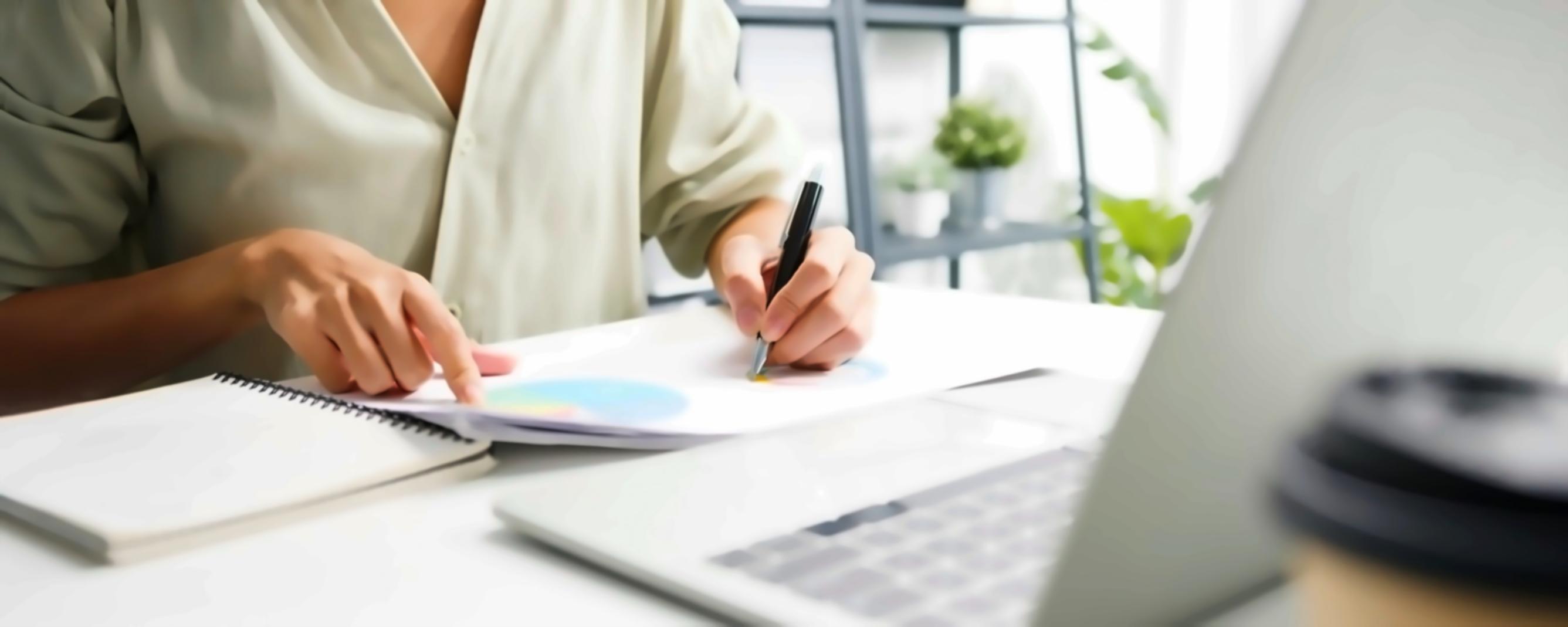 Arbeitsplatz mit Finanzberichten und Laptop